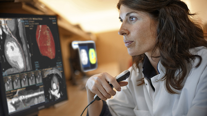 (opens in the same window) Interventional cardiologist looking at clinical images